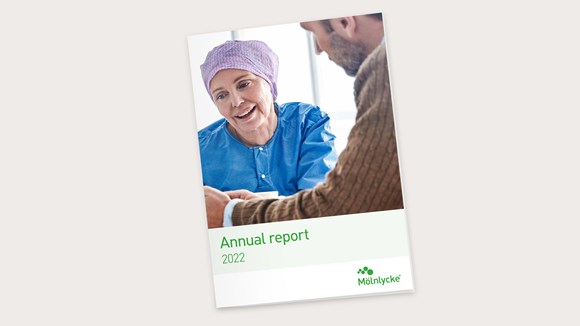 Mölnlycken vuoden 2022 vuosikertomuksen ja kestävän kehityksen raportin kansi, jossa on kuva lapsipotilaasta sairaanhoitajan kanssa
