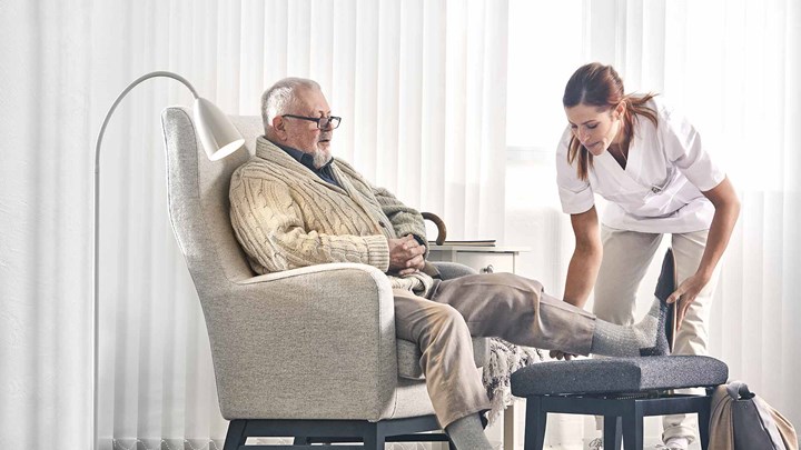 Terveydenhuollon ammattilainen auttaa vanhaa miestä