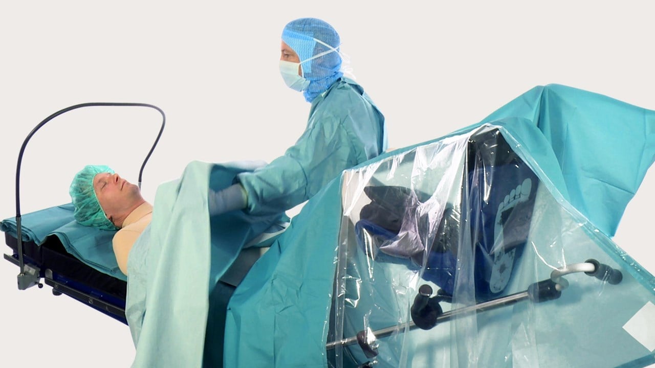 Terveydenhuollon ammattilainen peittelee potilaan BARRIER-leikkauslakanalla ennen kirurgista toimenpidettä