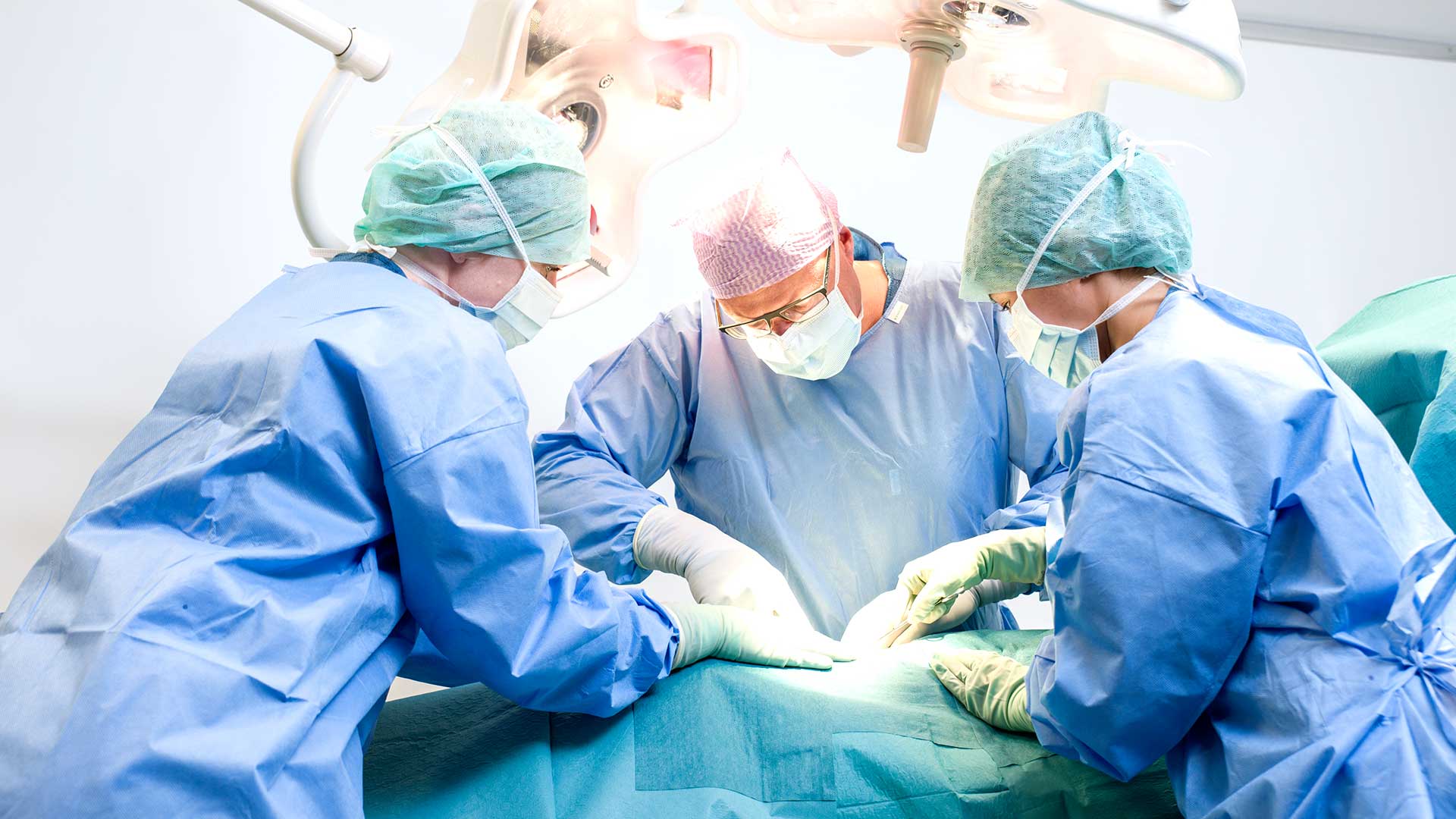 Kirurgi ja hoitajat työssään leikkaussalissa