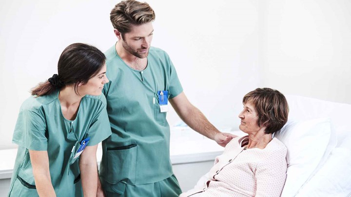 two health care professionals speaking with a patient